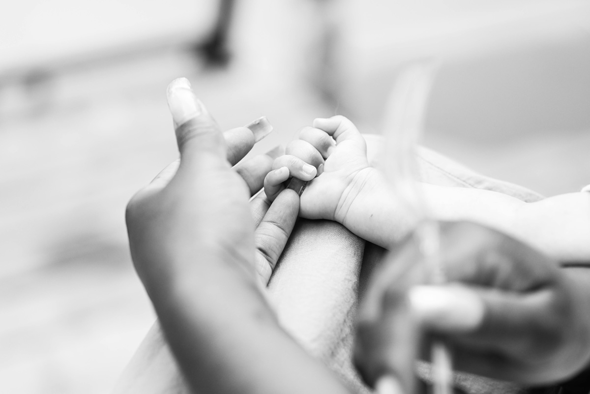 Baby's hand clasped on a woman's hand.